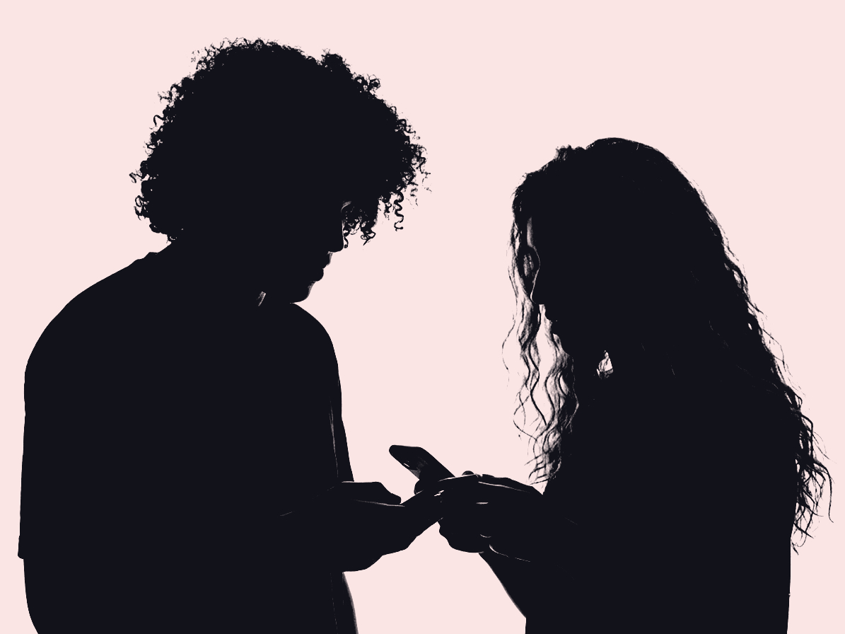 A high-contrast silhouette of our curly-haired protagonist and Anoush, his friend comparing details on their phone